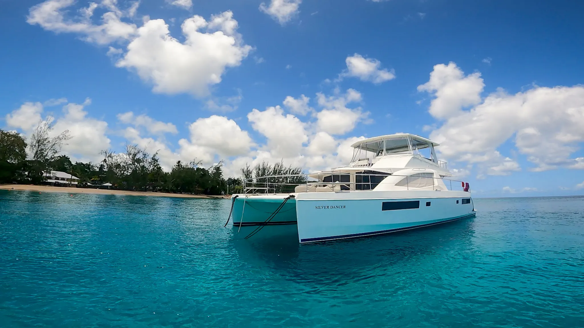 Silver Dancer from the water — bow view with beach behind