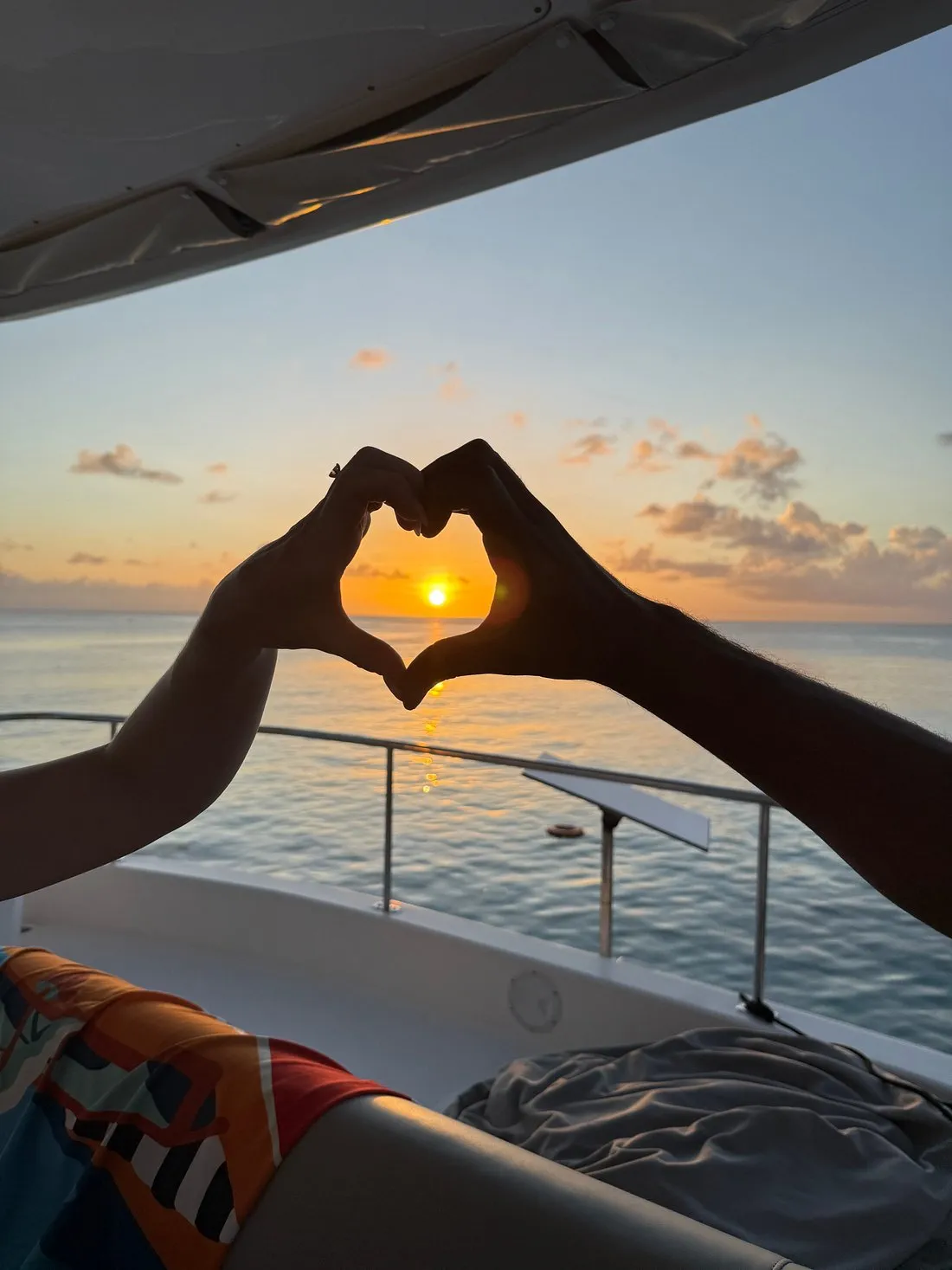 Heart hands framing the Caribbean sunset from the flybridge