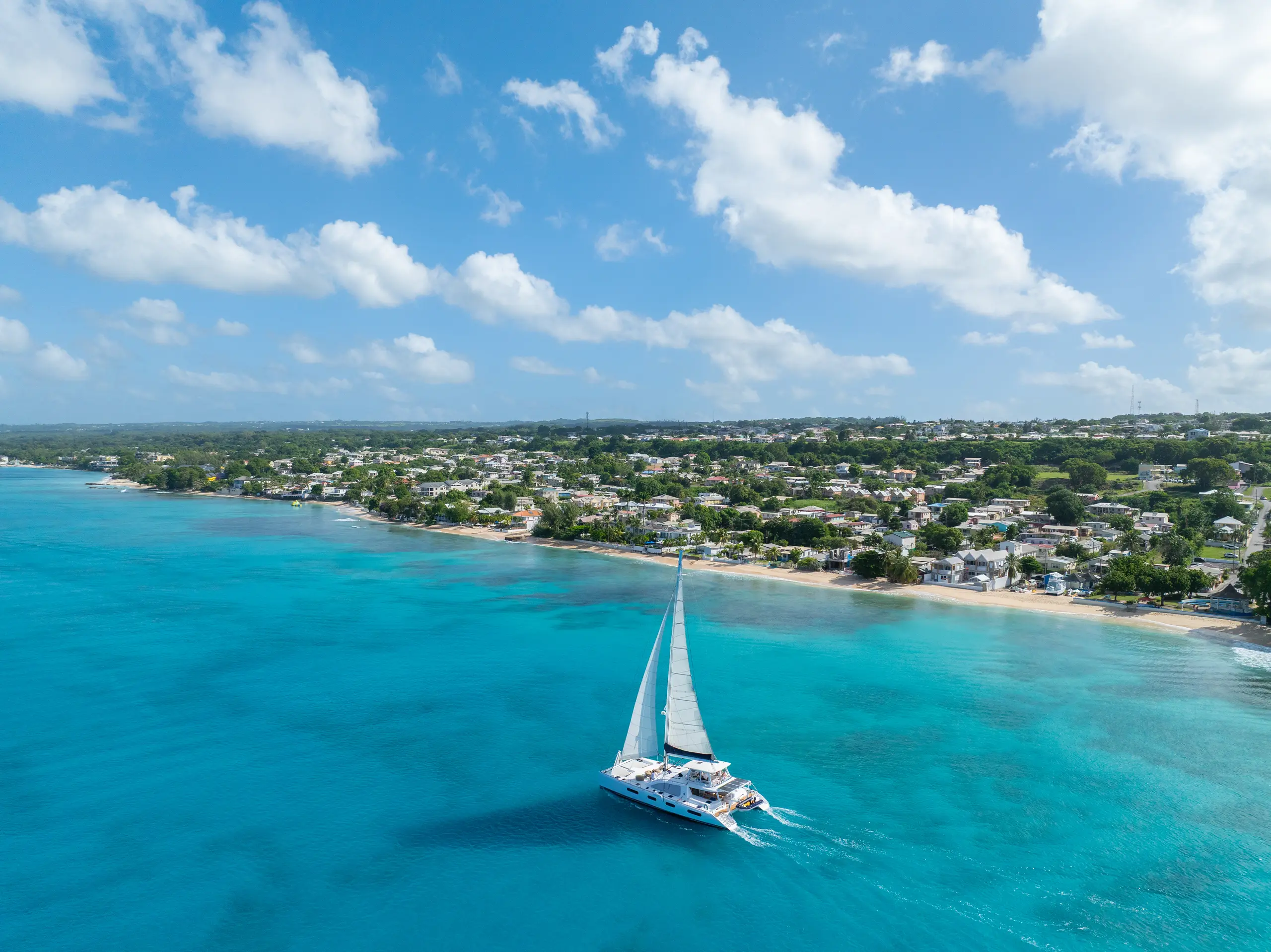 Aerial view of Silver Moon under sail near the coast